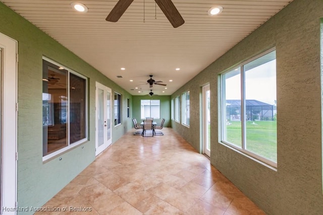 unfurnished sunroom with ceiling fan