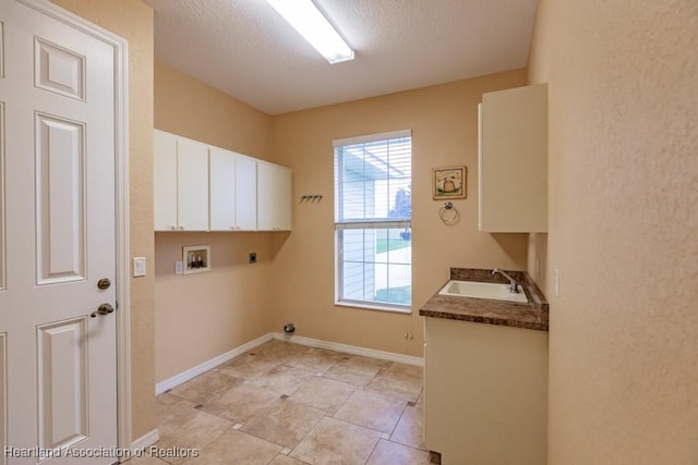 clothes washing area with hookup for an electric dryer, washer hookup, cabinets, a textured ceiling, and sink