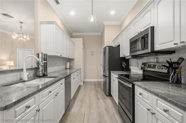 2036 Ashley Oaks Cir, Sebring, FL 33870 - kitchen featuring stainless steel appliances, crown molding, a sink, tasteful backsplash, and white cabinetry