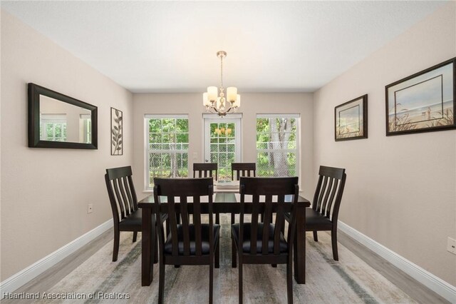 2036 Ashley Oaks Cir, Sebring, FL 33870 - dining room featuring a chandelier, baseboards, and light wood-style floors