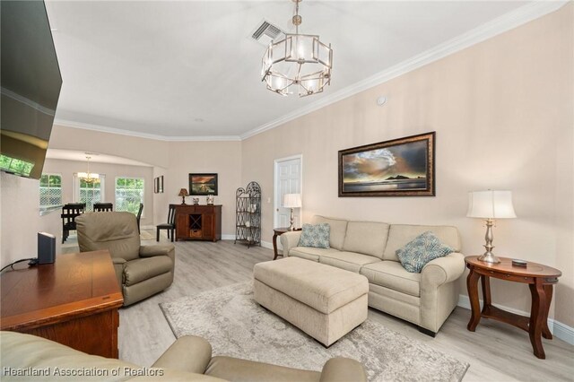 2036 Ashley Oaks Cir, Sebring, FL 33870 - living area with a chandelier, wood finished floors, baseboards, ornamental molding, and arched walkways