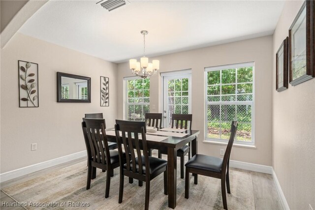 2036 Ashley Oaks Cir, Sebring, FL 33870 - dining space featuring a chandelier, baseboards, and light wood-type flooring