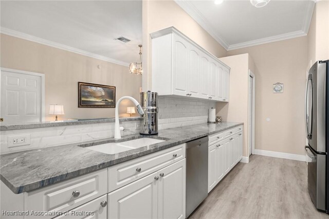 2036 Ashley Oaks Cir, Sebring, FL 33870 - kitchen featuring stainless steel appliances, a sink, ornamental molding, dark stone countertops, and white cabinets