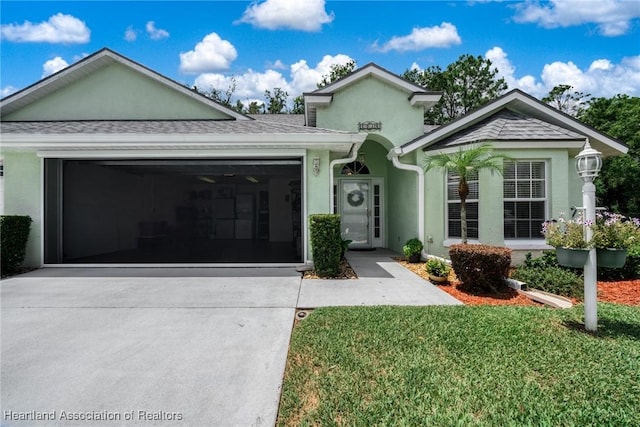 2036 Ashley Oaks Cir, Sebring, FL 33870 - view of front of property with an attached garage, concrete driveway, stucco siding, and a front lawn