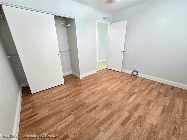 unfurnished bedroom with a closet and light wood-type flooring