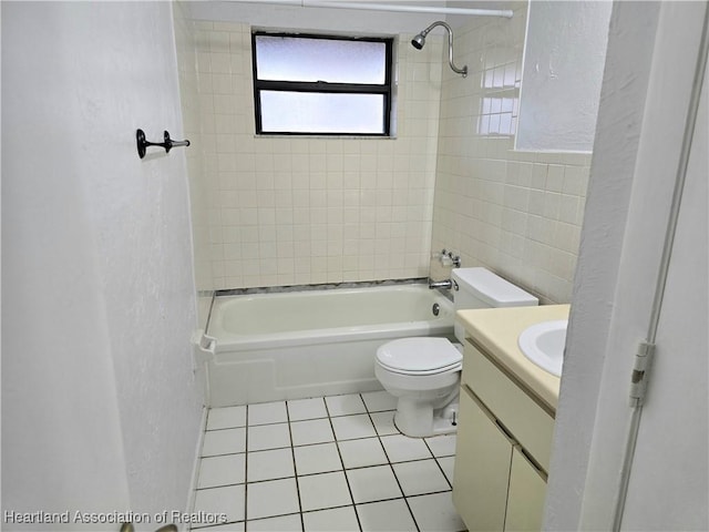 full bathroom featuring vanity, toilet, tiled shower / bath combo, and tile patterned flooring