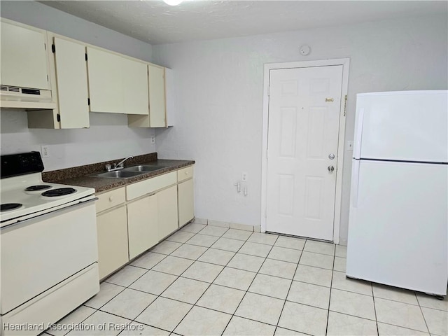 kitchen with sink, light tile patterned floors, white appliances, and cream cabinetry