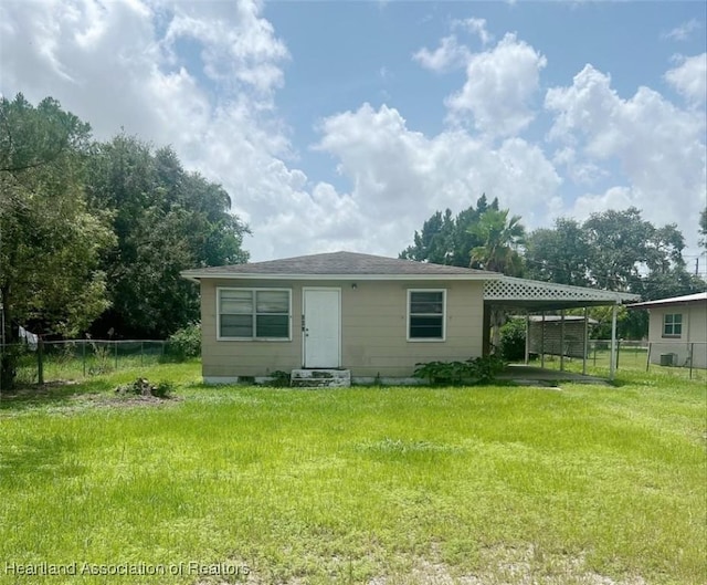 rear view of property with a yard and a carport