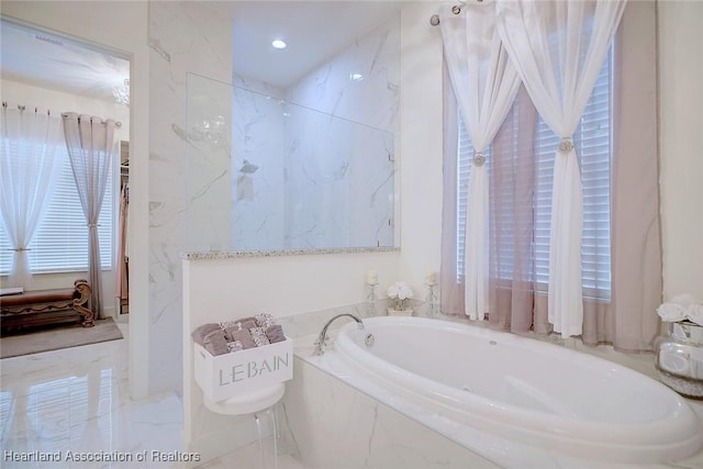 bathroom with a relaxing tiled tub