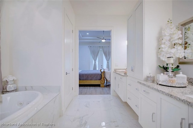 bathroom with ceiling fan, tiled bath, and vanity