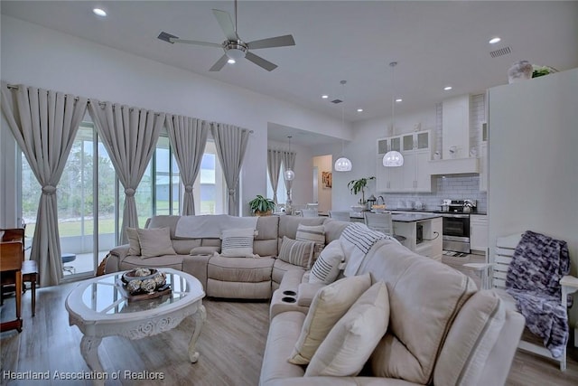 living room with ceiling fan and light hardwood / wood-style flooring