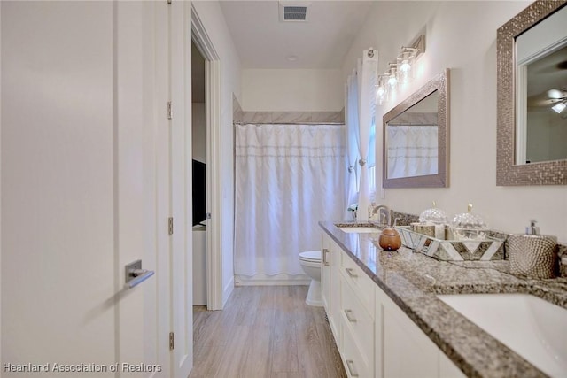 bathroom featuring hardwood / wood-style floors, toilet, vanity, and a shower with shower curtain