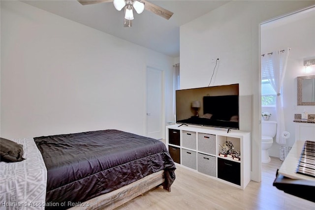 bedroom featuring light wood-type flooring, ceiling fan, and connected bathroom