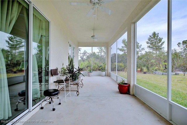 unfurnished sunroom featuring ceiling fan and a healthy amount of sunlight