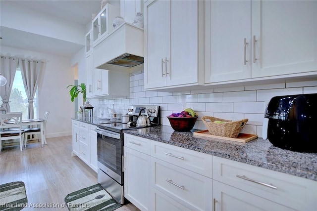 kitchen featuring decorative backsplash, light hardwood / wood-style flooring, stainless steel electric range oven, light stone countertops, and white cabinets