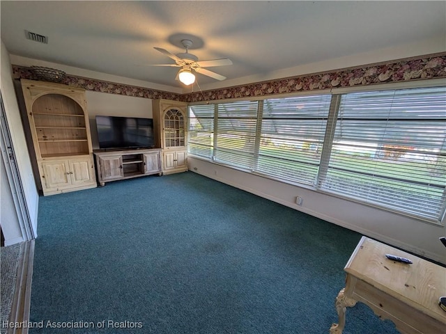 unfurnished living room featuring dark carpet and ceiling fan