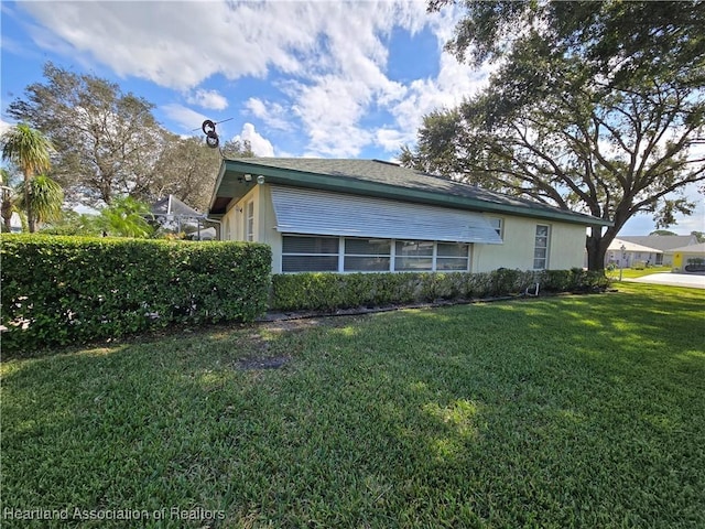 view of side of home with a yard