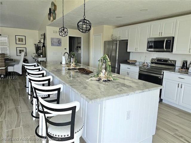 325 Anderson St NE, Lake Placid, FL 33852 - kitchen with hanging light fixtures, white cabinetry, appliances with stainless steel finishes, and light stone countertops