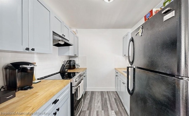 kitchen with black refrigerator, light wood-type flooring, backsplash, electric range, and white cabinetry