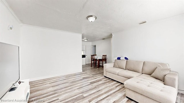 living room with light wood-type flooring and ornamental molding