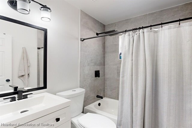 full bathroom with vanity, shower / bath combination with curtain, and toilet