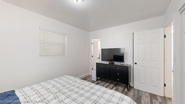 bedroom with dark hardwood / wood-style flooring