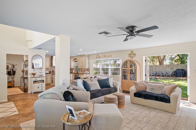 living room featuring ceiling fan, visible vents, and recessed lighting