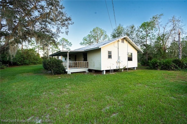 rear view of house with a lawn and covered porch