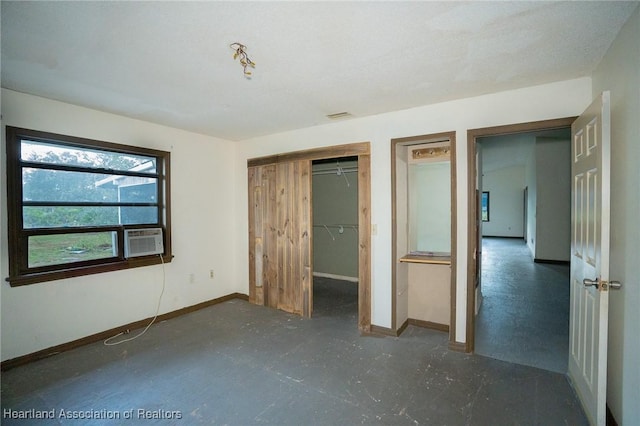 unfurnished bedroom featuring cooling unit and a closet