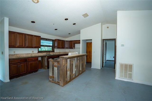 kitchen featuring a kitchen island, lofted ceiling, and sink