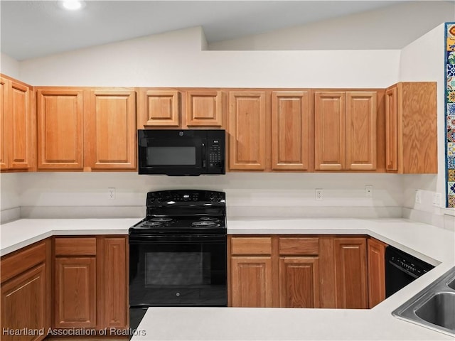 kitchen with sink, black appliances, and vaulted ceiling