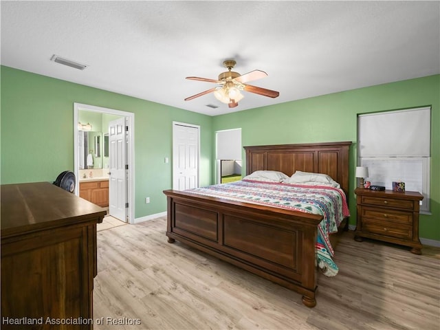 bedroom with connected bathroom, a closet, light hardwood / wood-style flooring, and ceiling fan