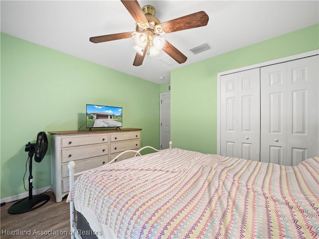 bedroom featuring ceiling fan, a closet, and hardwood / wood-style flooring