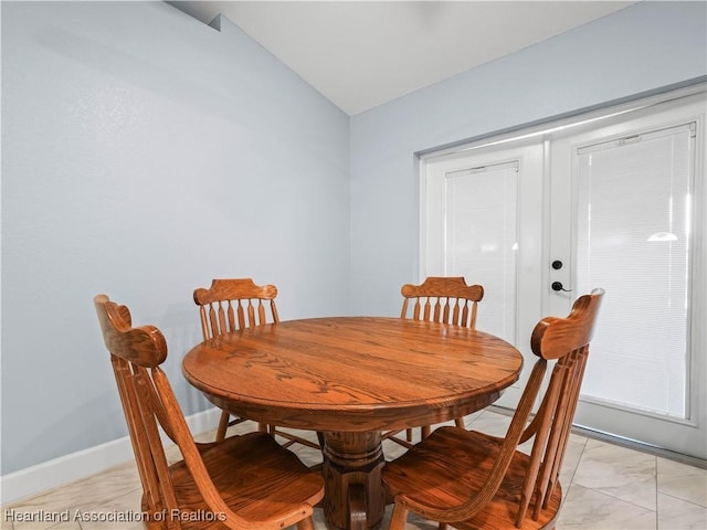 dining space featuring vaulted ceiling