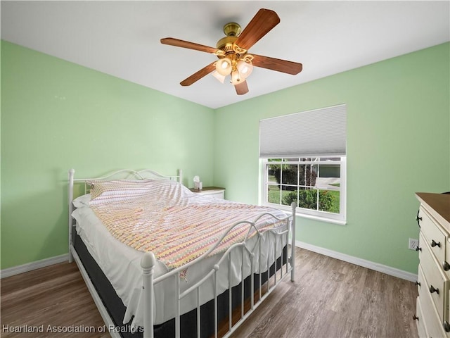 bedroom with ceiling fan and dark wood-type flooring