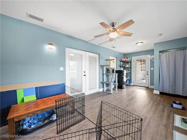 living room with hardwood / wood-style floors, ceiling fan, and french doors