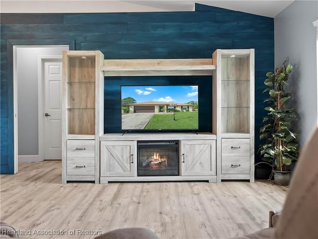 unfurnished living room featuring hardwood / wood-style floors and vaulted ceiling