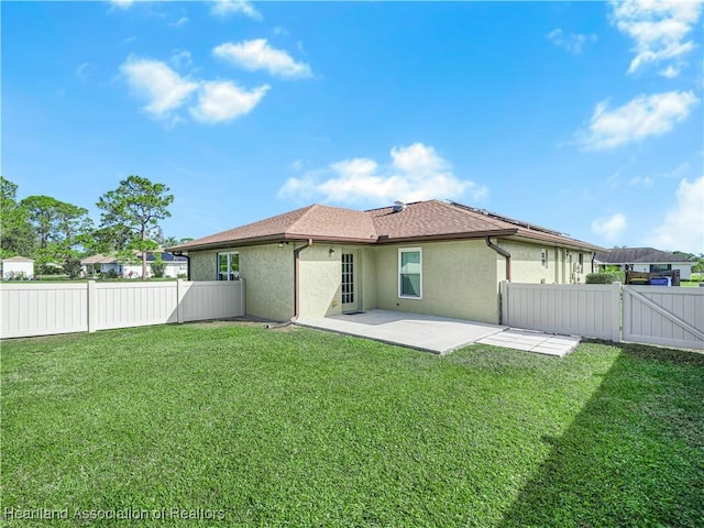 rear view of house with a yard and a patio area