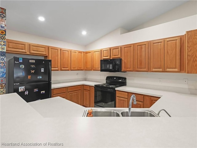 kitchen with sink, lofted ceiling, and black appliances