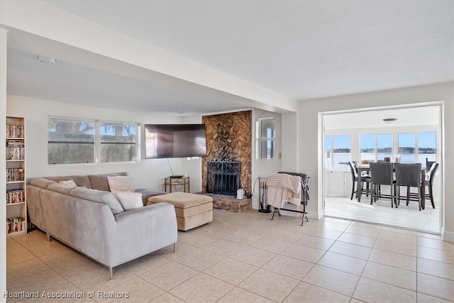 living room with a fireplace and light tile patterned flooring