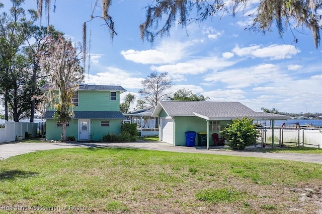 view of front of property featuring a garage, a front yard, and a water view