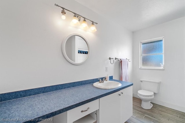 bathroom featuring vanity, hardwood / wood-style flooring, and toilet