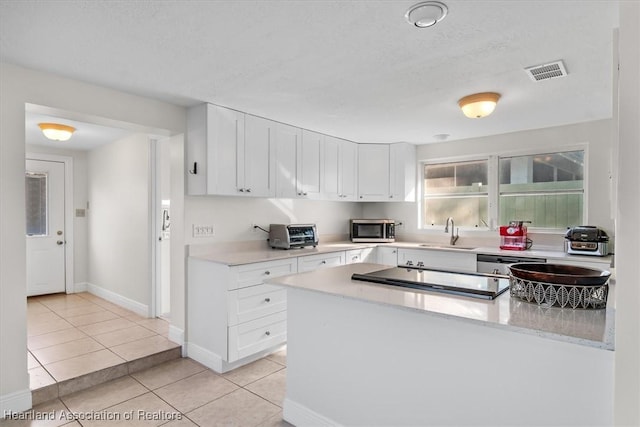 kitchen featuring light tile patterned flooring, sink, light stone counters, stainless steel appliances, and white cabinets