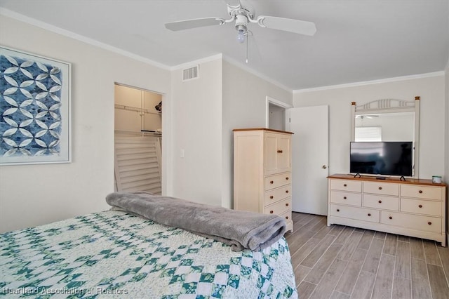 bedroom with ornamental molding, a closet, ceiling fan, and light hardwood / wood-style flooring