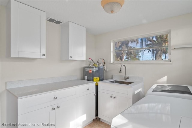 washroom with sink, washing machine and dryer, and cabinets