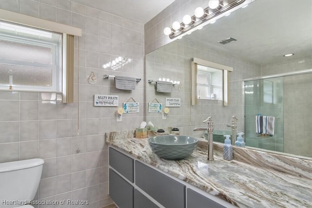 bathroom featuring plenty of natural light and tile walls