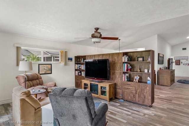 living room featuring ceiling fan, wood-type flooring, and lofted ceiling