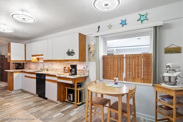 kitchen with tasteful backsplash, dishwasher, white cabinets, and light hardwood / wood-style floors