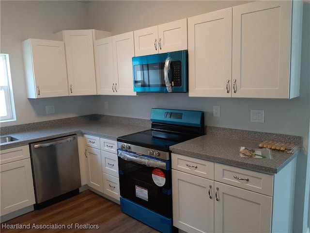 1508 Las Villas Blvd, Sebring, FL 33870 - kitchen with stainless steel appliances, white cabinetry, dark wood-style floors, and a sink
