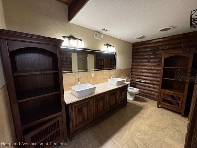 2204 US-27 Hwy S, Lake Placid, FL 33852 - bathroom featuring visible vents, log walls, a sink, and a textured ceiling